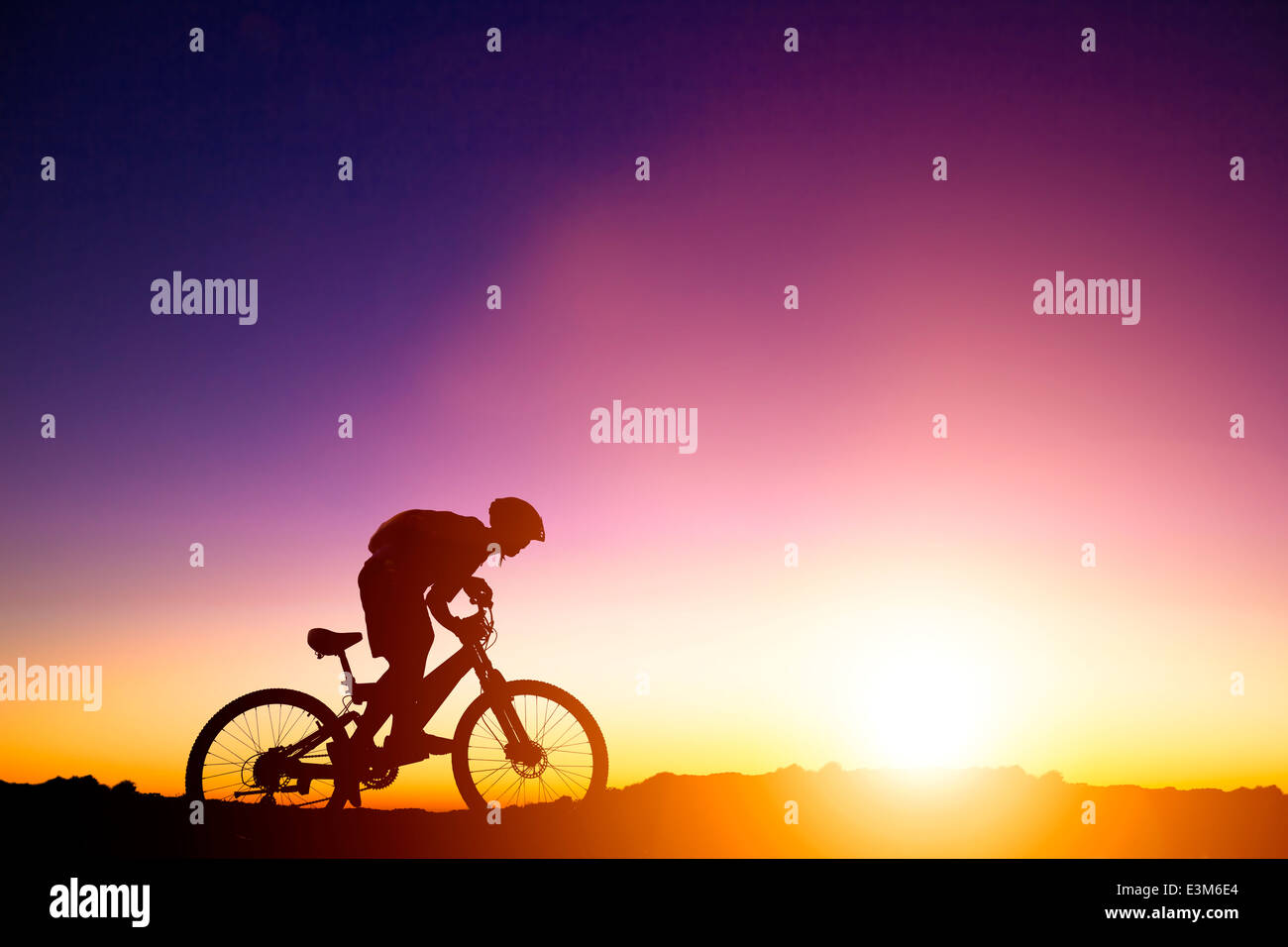 Mountain Bicycle rider sulla collina con lo sfondo di sunrise Foto Stock