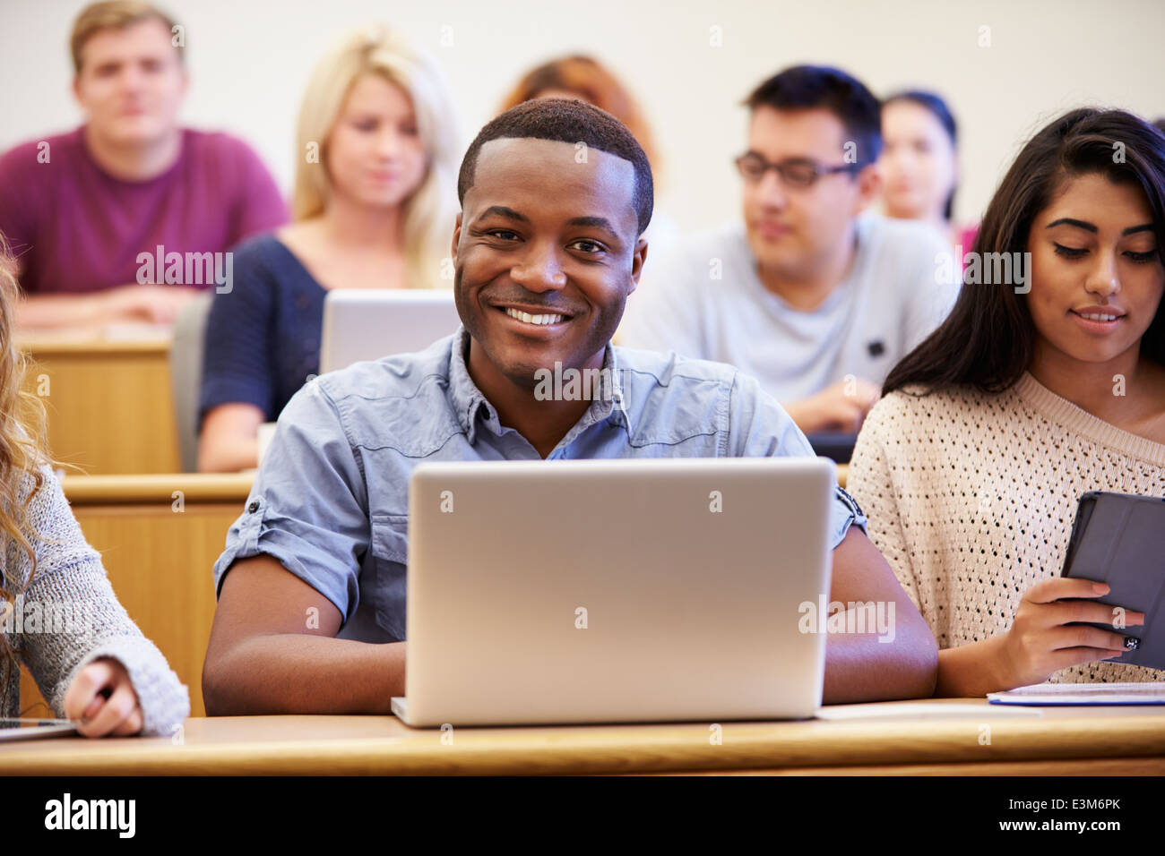 Maschio studente universitario utilizzando laptop in conferenza Foto Stock