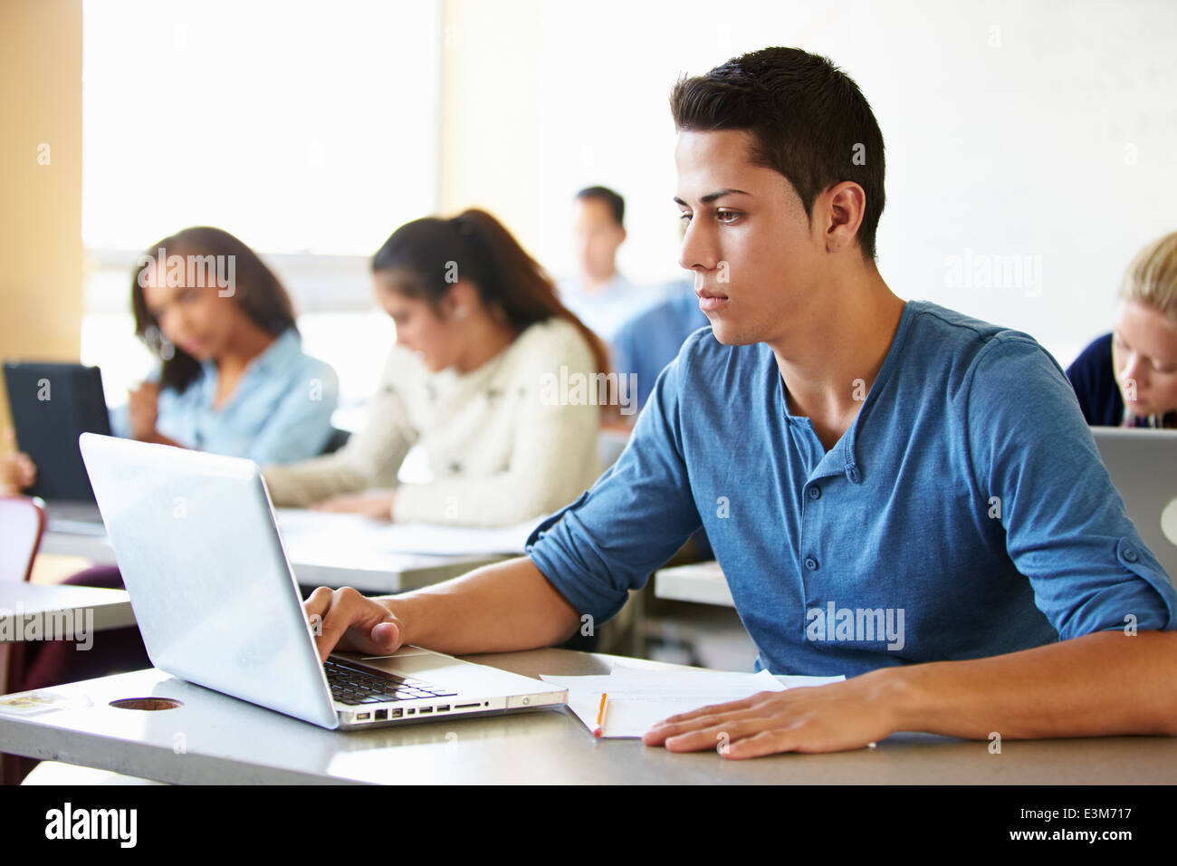 Maschio di alta scuola studente utilizzando laptop in classe Foto Stock
