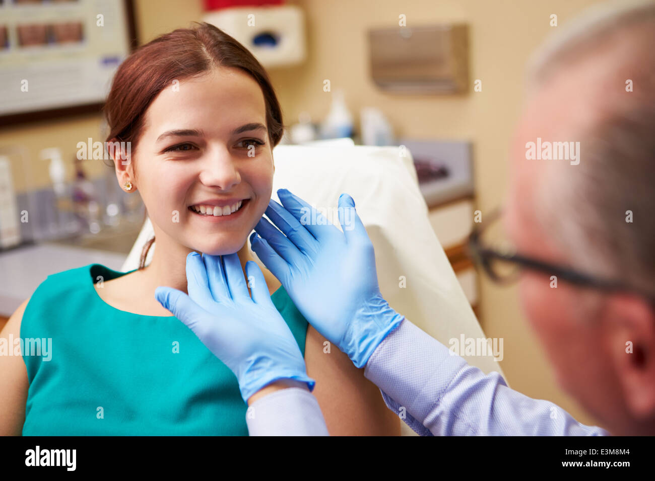 Chirurgo cosmetico esaminando femmina nel client di Office Foto Stock