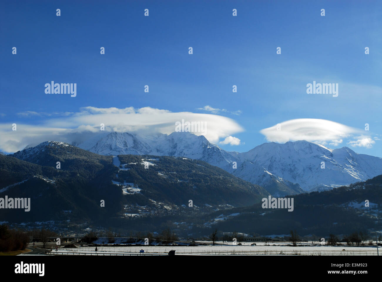 Il Mont Blanc su una soleggiata giornata invernale con nubi lenticolari al di sopra di due delle sue cime Foto Stock