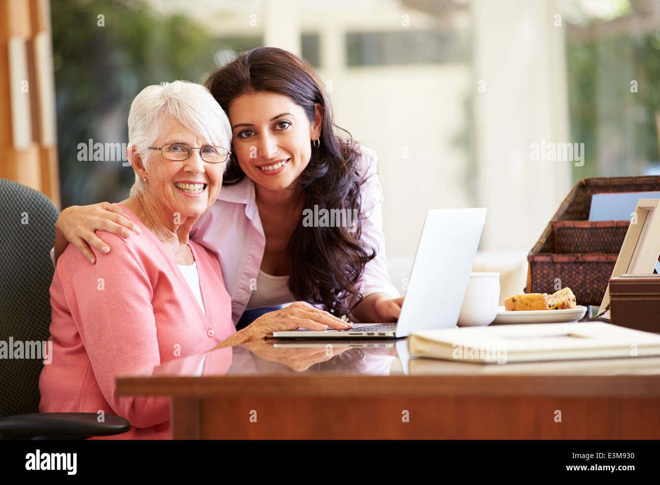 Figlia adulta aiutando la madre con il computer portatile Foto Stock