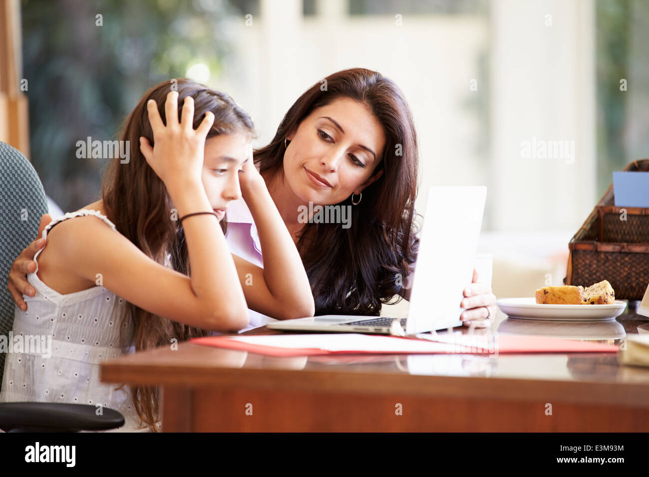 Madre aiutare sottolineato figlia adolescente guardando al laptop Foto Stock