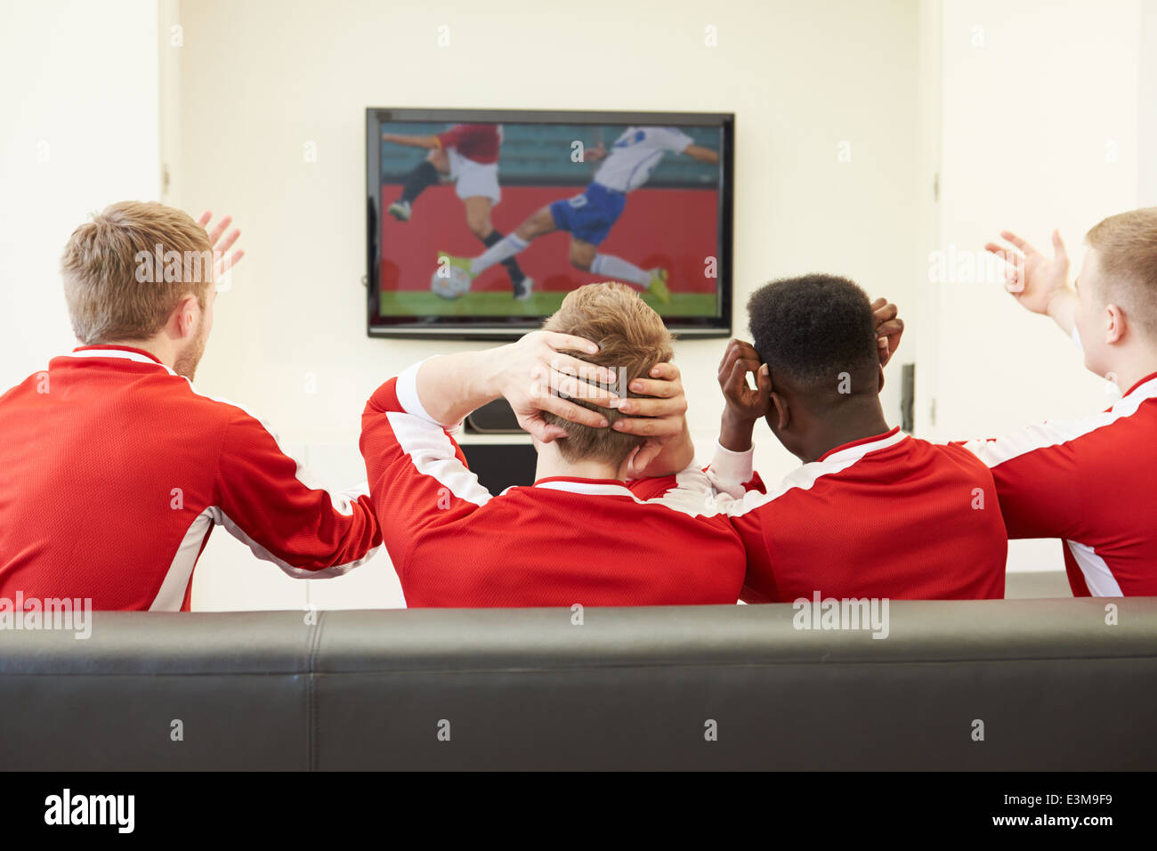Gruppo di appassionati di sport la visione di gioco sulla TV di casa Foto Stock
