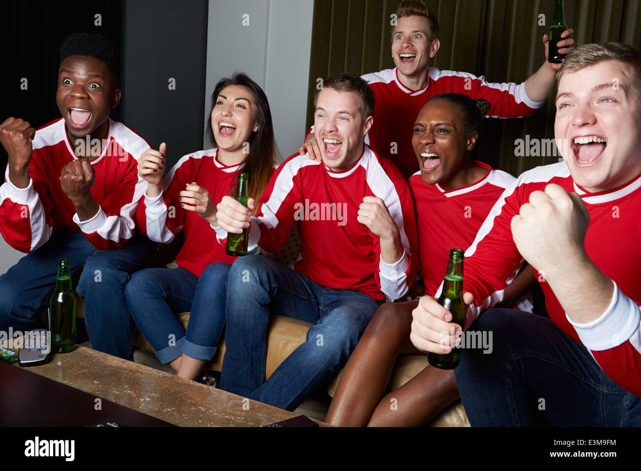 Gruppo di appassionati di sport la visione di gioco sulla TV di casa Foto Stock