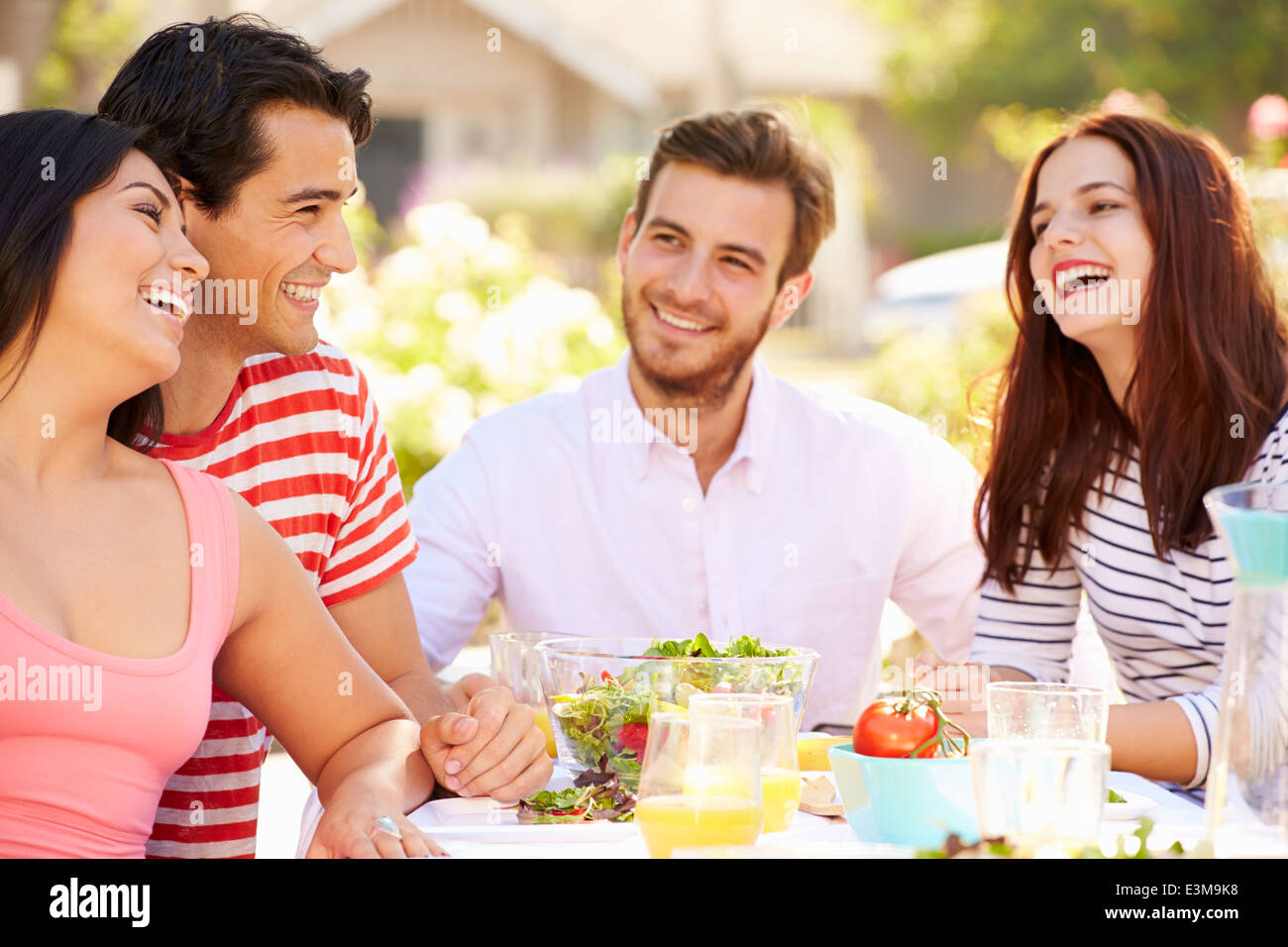 Gruppo di amici godendo di pasto al party all'aperto in cortile Foto Stock