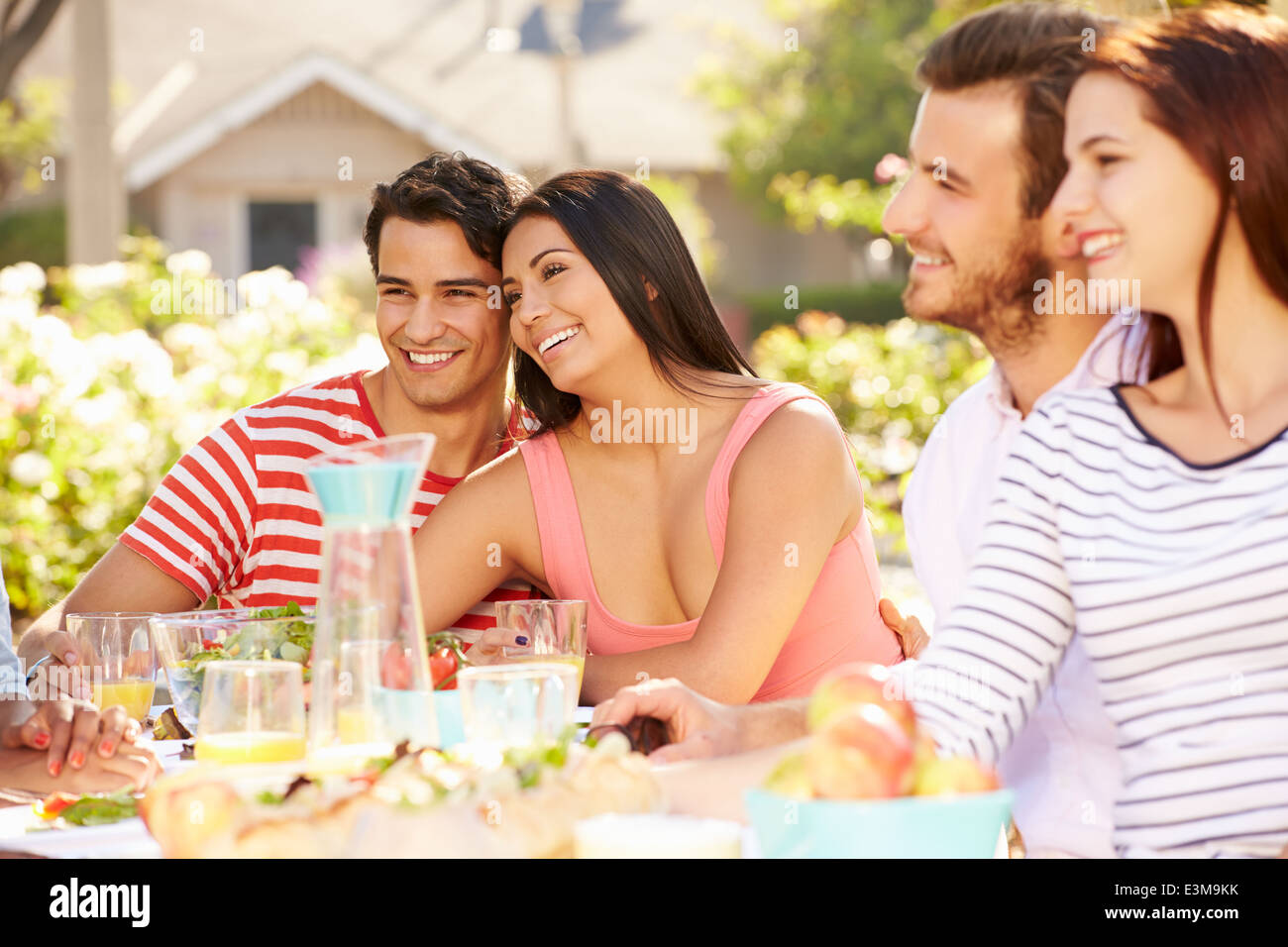 Gruppo di amici godendo di pasto al party all'aperto in cortile Foto Stock