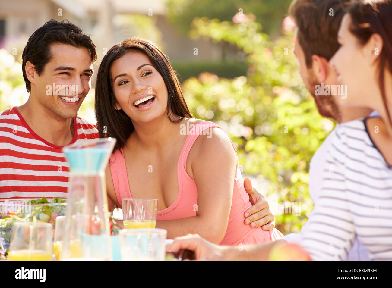 Gruppo di amici godendo di pasto al party all'aperto in cortile Foto Stock
