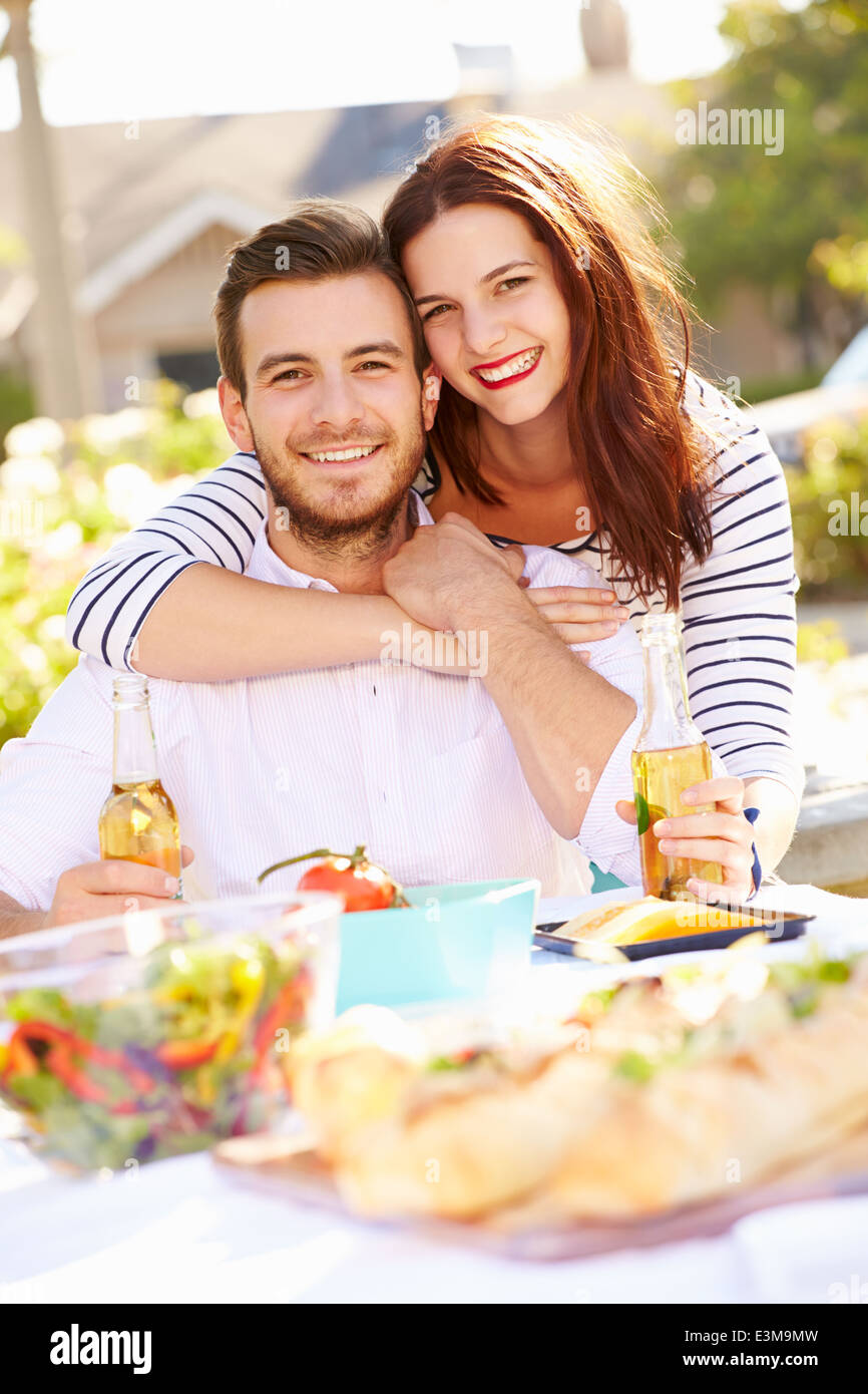 Coppia romantica gustando pasti all'aperto in giardino Foto Stock