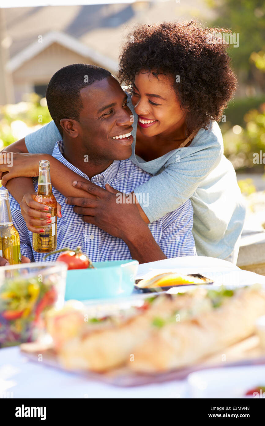 Coppia romantica gustando pasti all'aperto in giardino Foto Stock