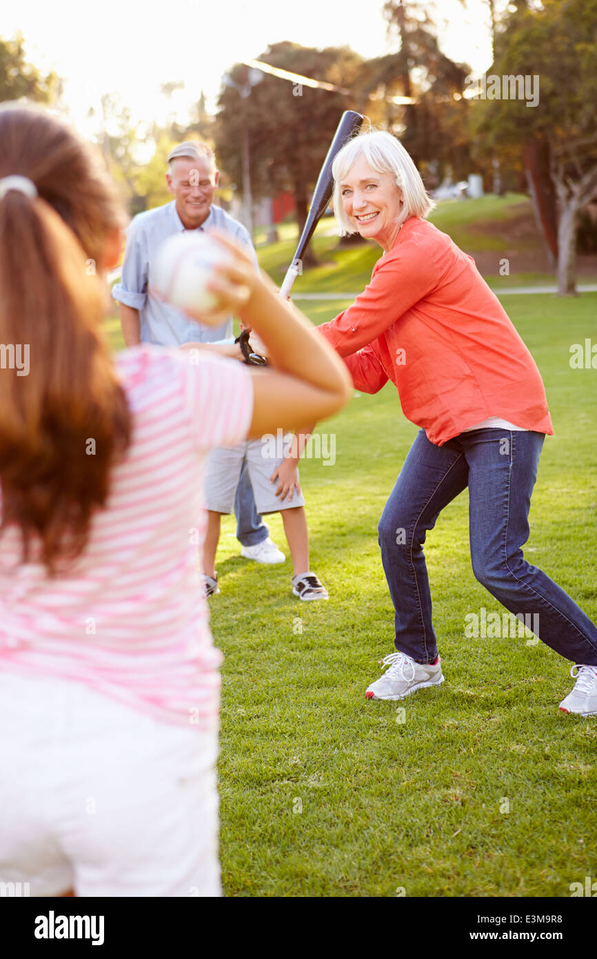 Nonni a giocare a baseball con i nipoti in posizione di parcheggio Foto Stock