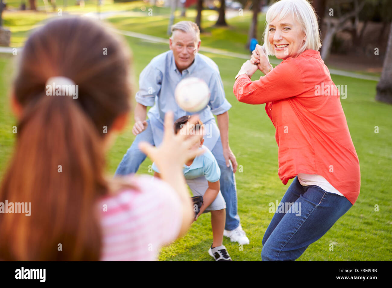 Nonni a giocare a baseball con i nipoti in posizione di parcheggio Foto Stock