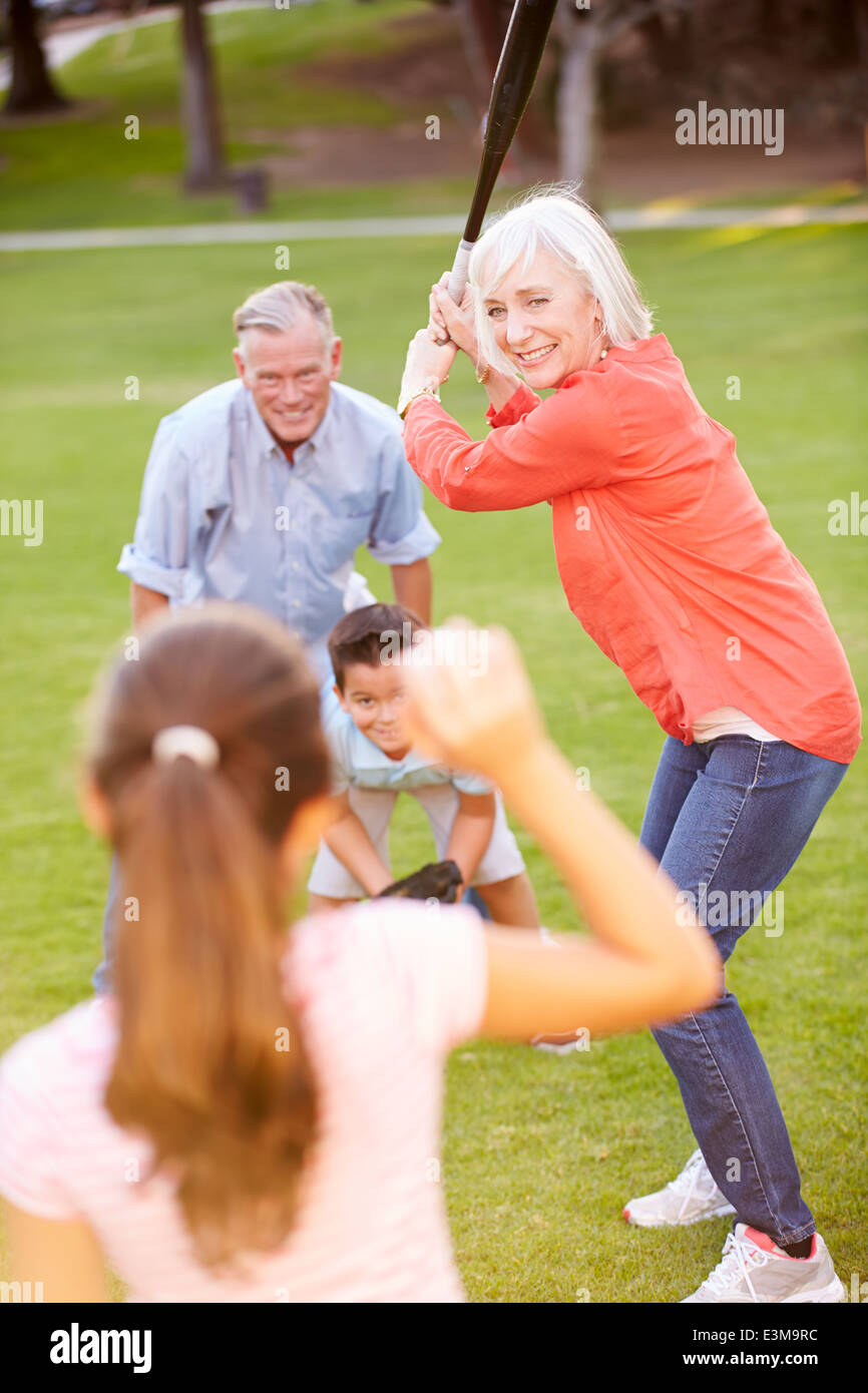Nonni a giocare a baseball con i nipoti in posizione di parcheggio Foto Stock