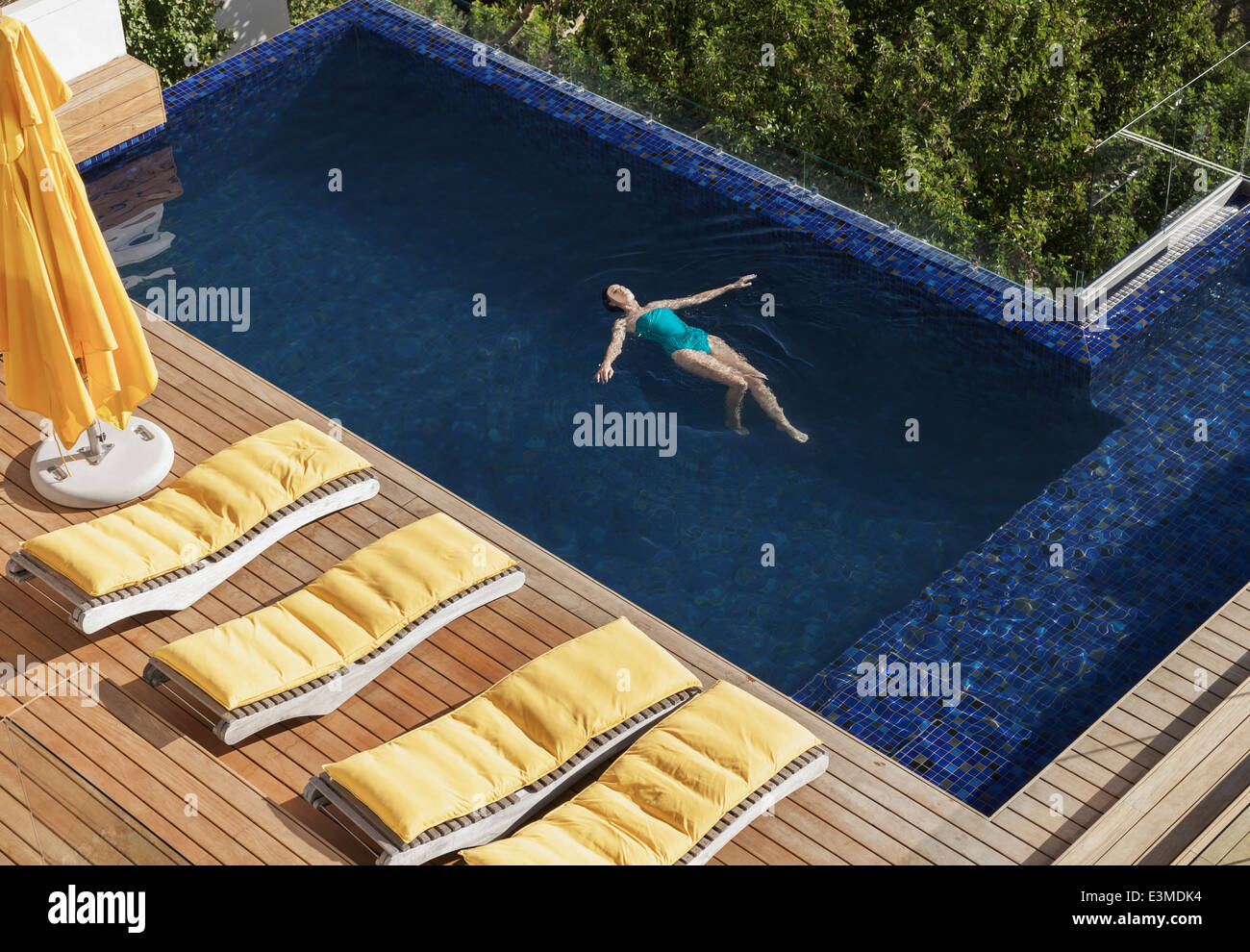 Donna galleggianti in piscina di lusso Foto Stock