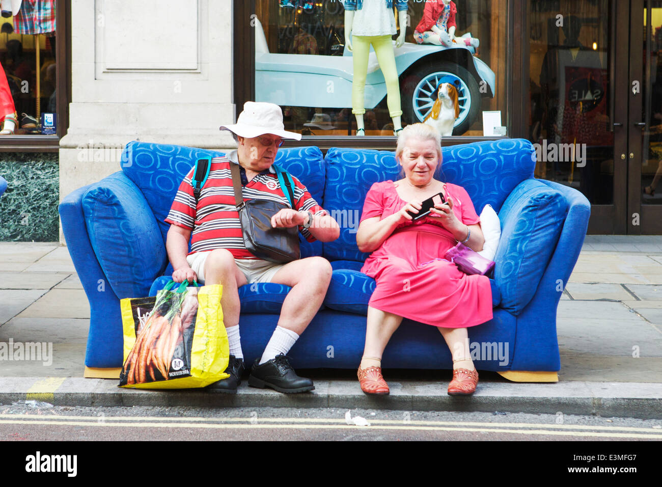 Shopping in Regent Street, Londra UK. Coppia di anziani pensionati seduta su un divano dopo un viaggio di shopping. I pensionati UK. Shopping a Londra. Foto Stock