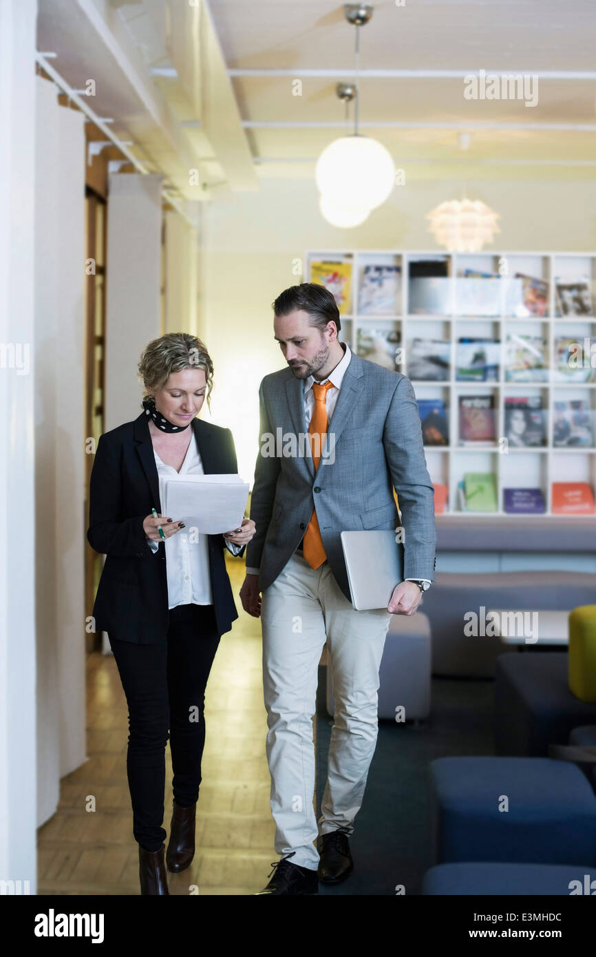 Imprenditrice maturo e imprenditore con la documentazione in ufficio creativo Foto Stock