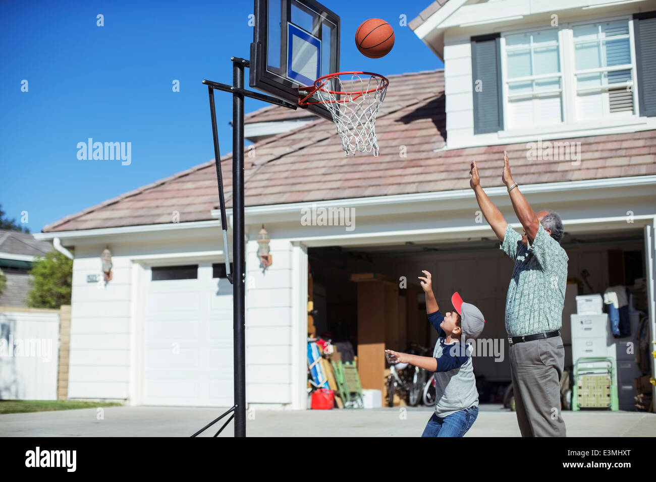 Nonno e nipote giocare a basket in viale di accesso Foto Stock