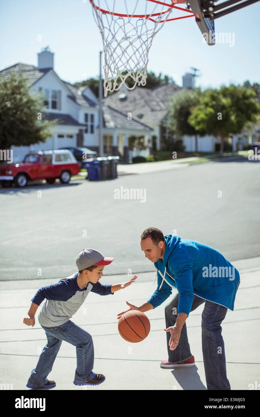 Padre e figlio giocare a basket in viale di accesso Foto Stock