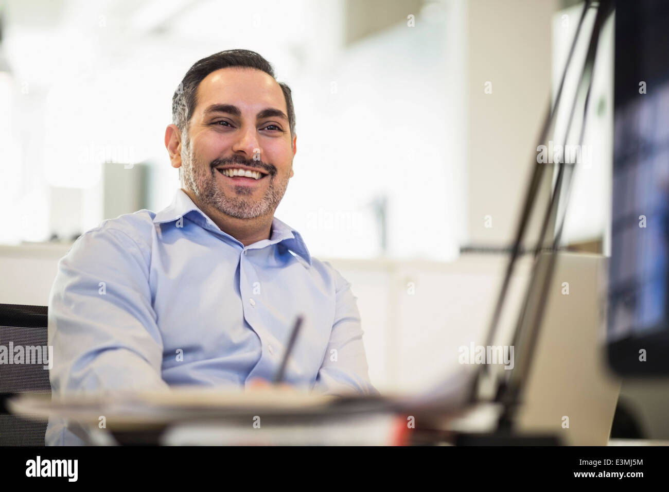 Happy businessman guardando lontano in office Foto Stock