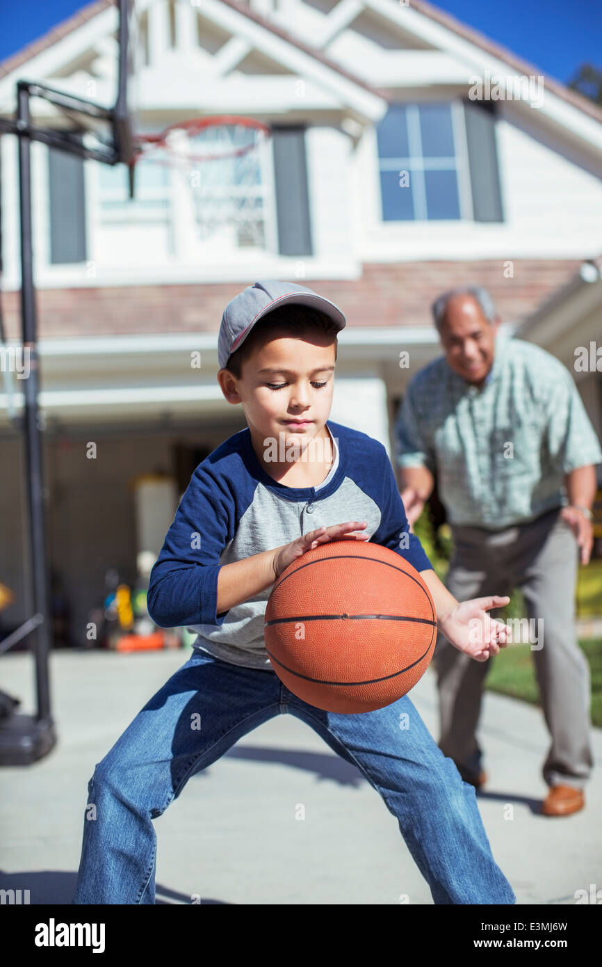Nonno e nipote giocare a basket in viale di accesso Foto Stock