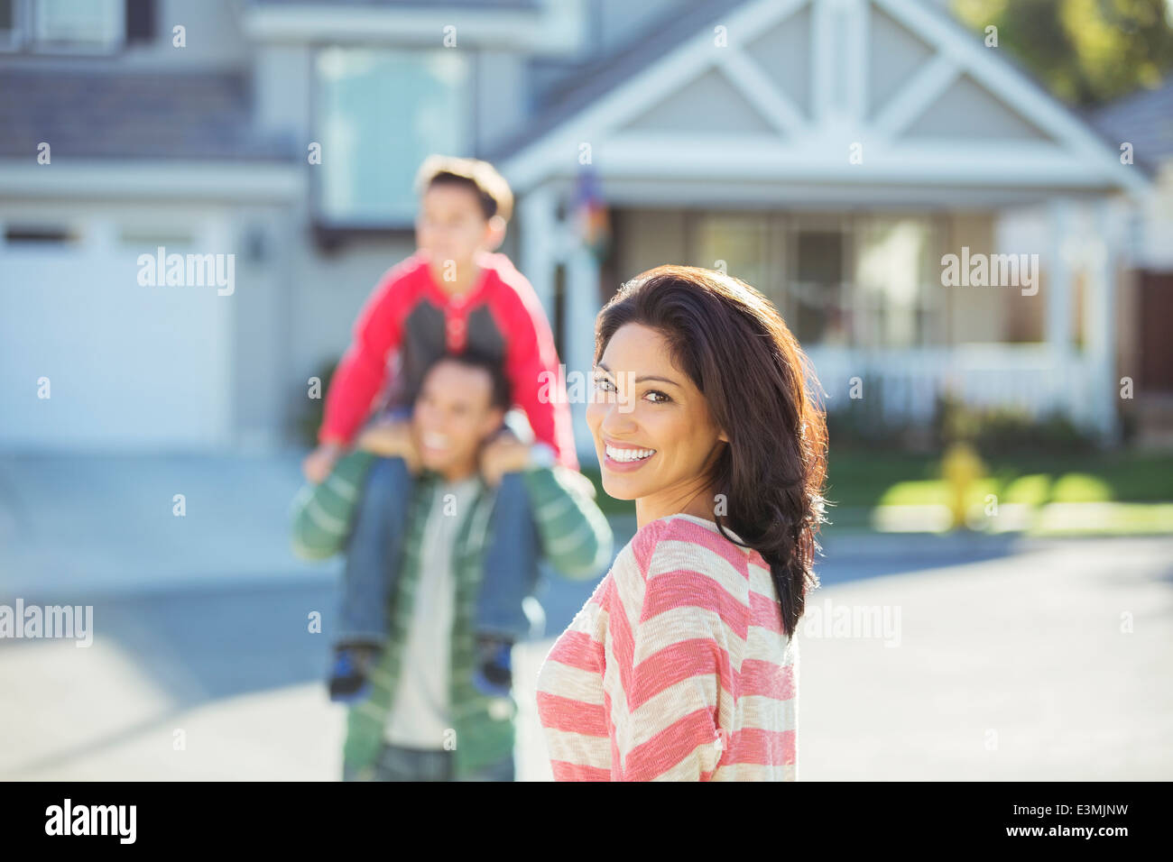 Ritratto di donna sorridente con la famiglia sulla strada Foto Stock