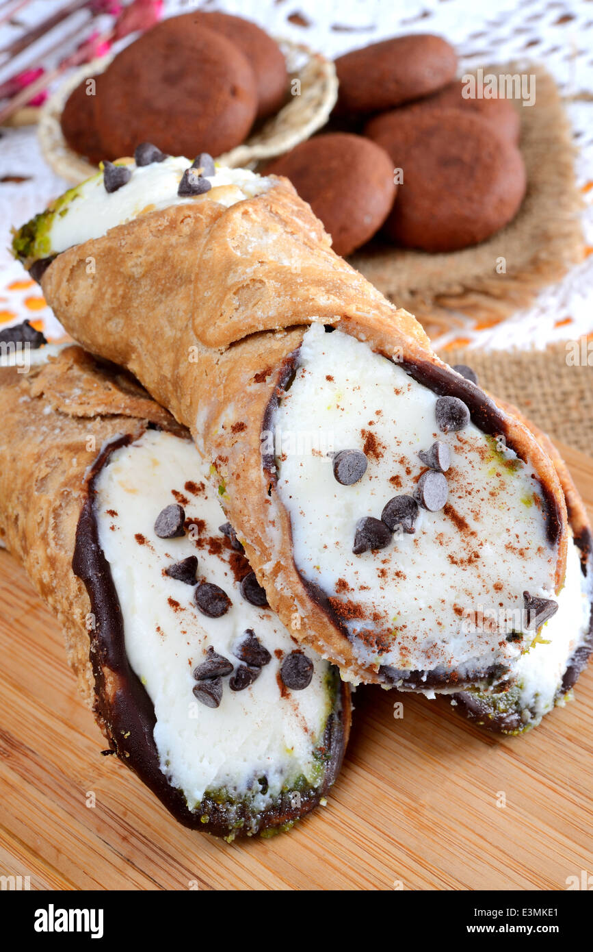 Molto dolce cannoli siciliani riempiti da la ricotta e lo zucchero con pistacchi e gocce di cioccolato Foto Stock