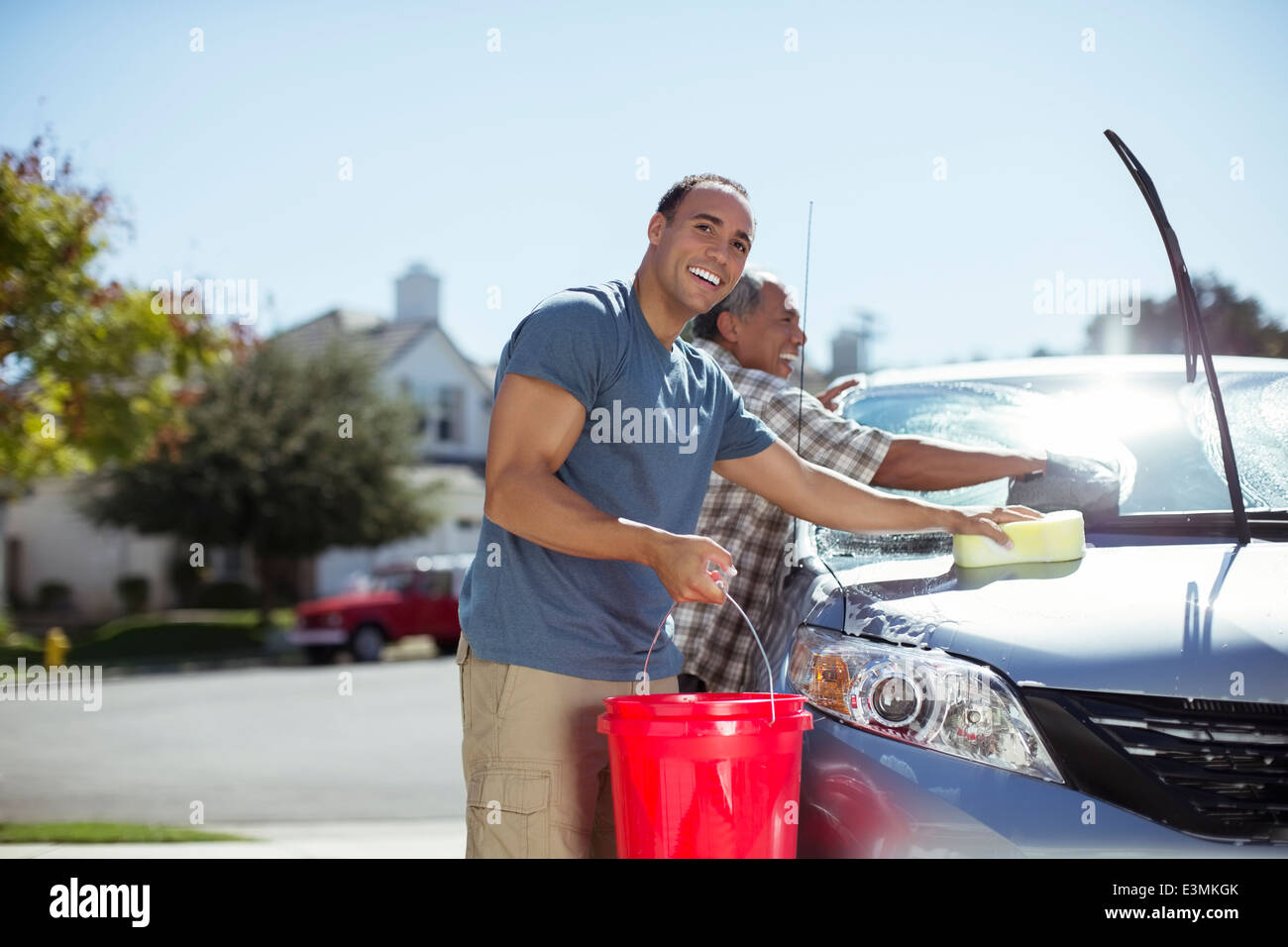 Padre e figlio il lavaggio auto nel viale di accesso Foto Stock