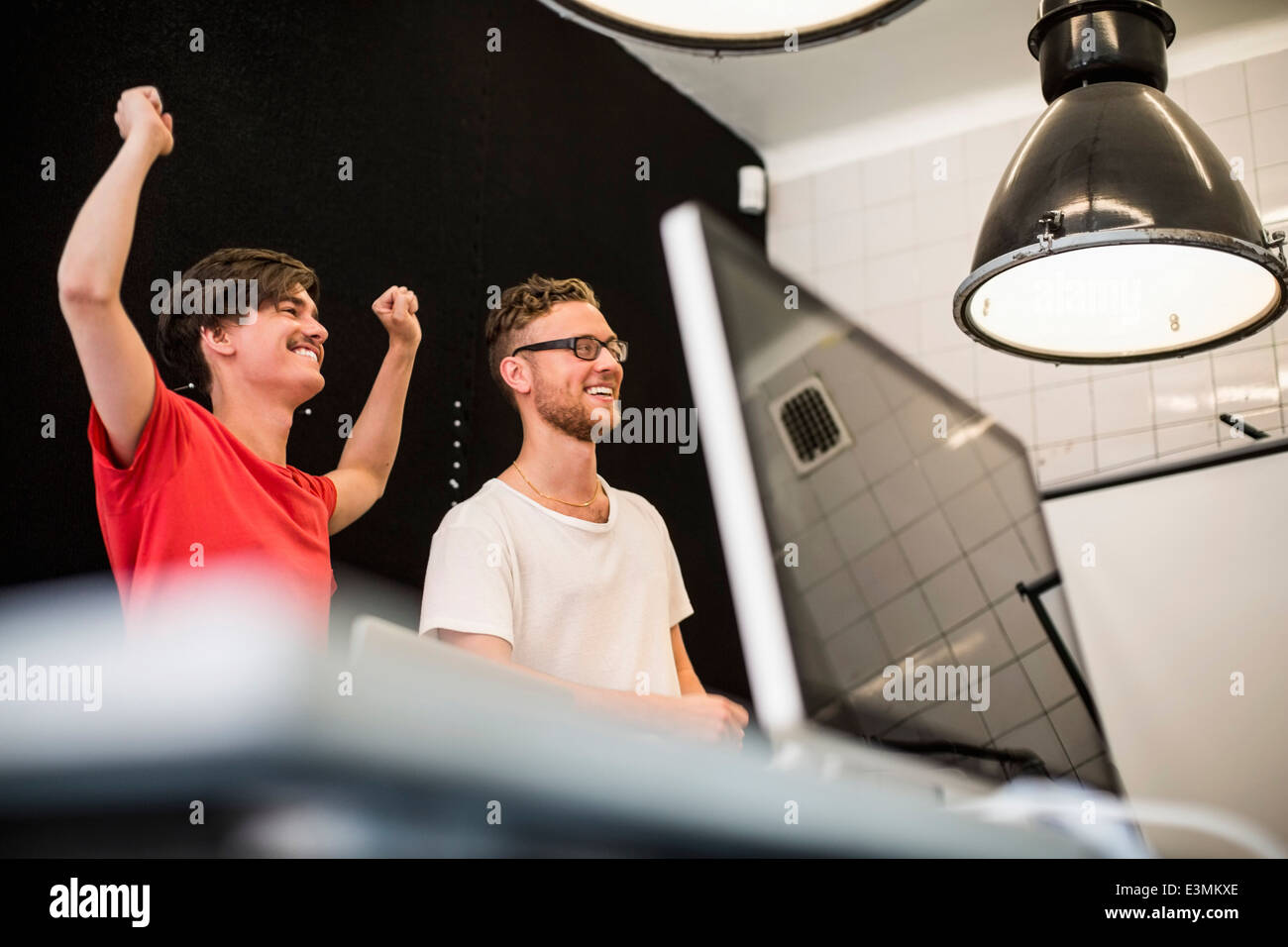 Felice di giovani uomini di affari che per celebrare il successo nel nuovo ufficio Foto Stock