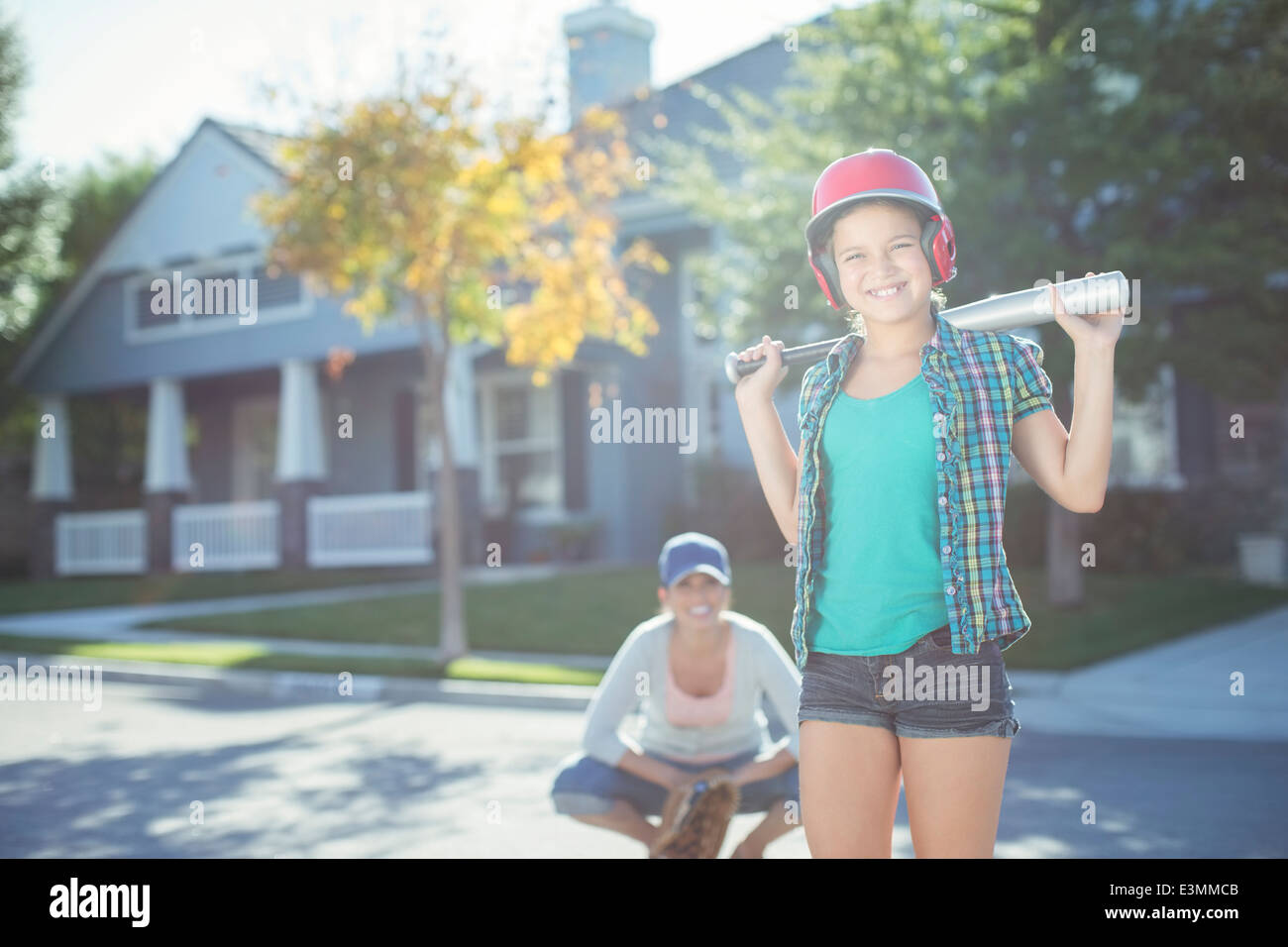 Ritratto di Madre e figlia a giocare a baseball in strada Foto Stock
