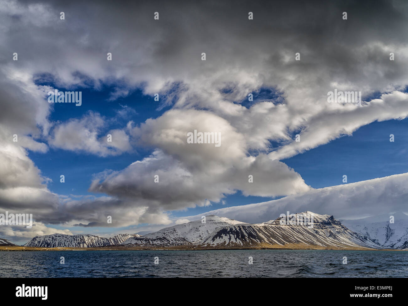 Cumulus nubi su montagne coperte di neve, Grundarfjordur, Islanda Foto Stock