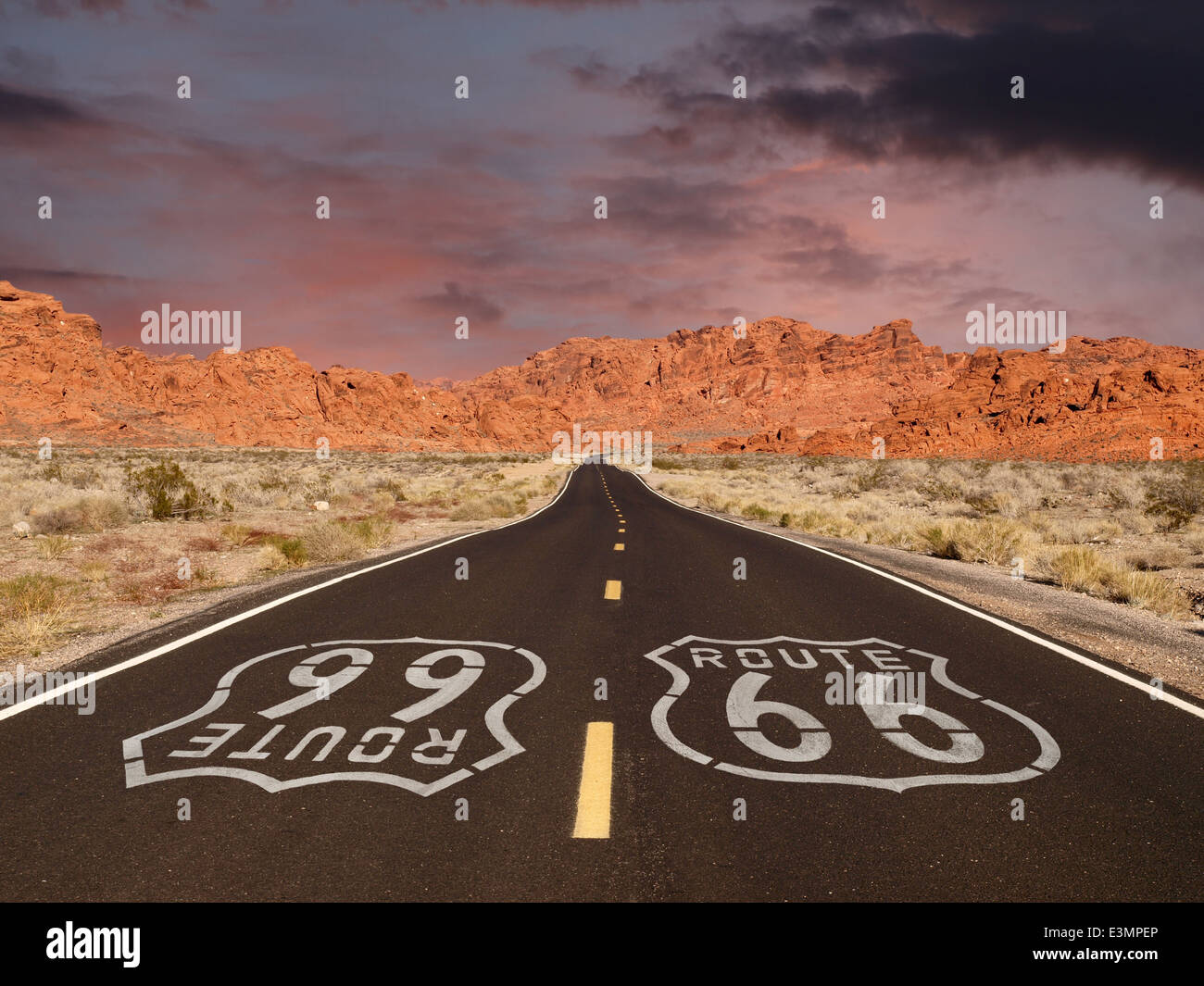 Route 66 marciapiede di firmare con il Mojave Desert red rock tramonti sulle montagne. Foto Stock