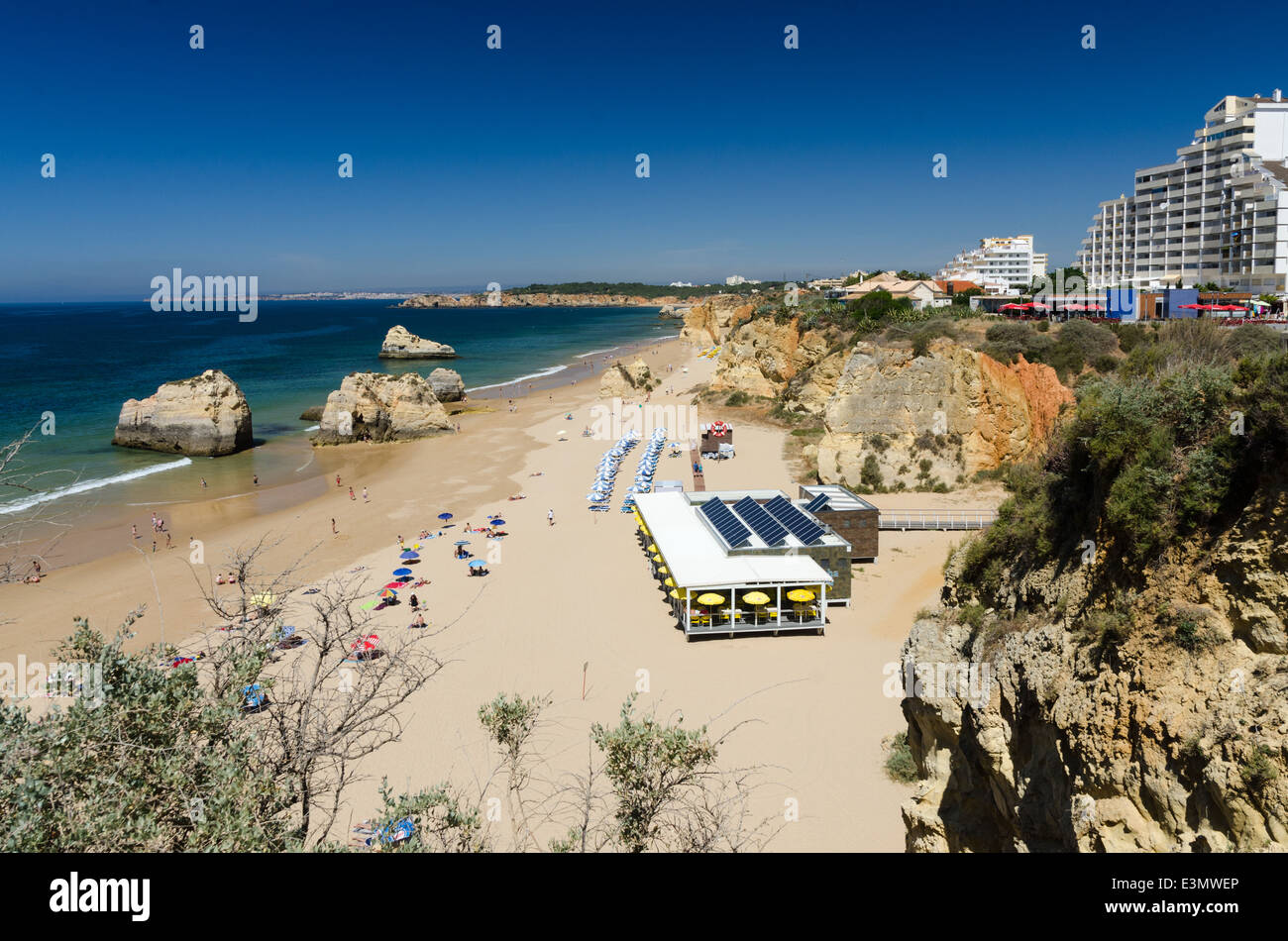 Il ristorante e la fila di sedie a sdraio sulla grande spiaggia di sabbia di Praia da Rocha, Portimao in Algarve Foto Stock