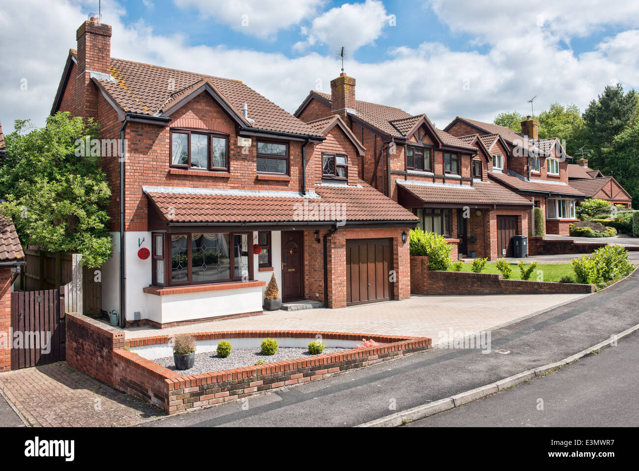 Una tipica riga di suburban staccato case su un soleggiato street a Swindon, Wiltshire, Regno Unito Foto Stock