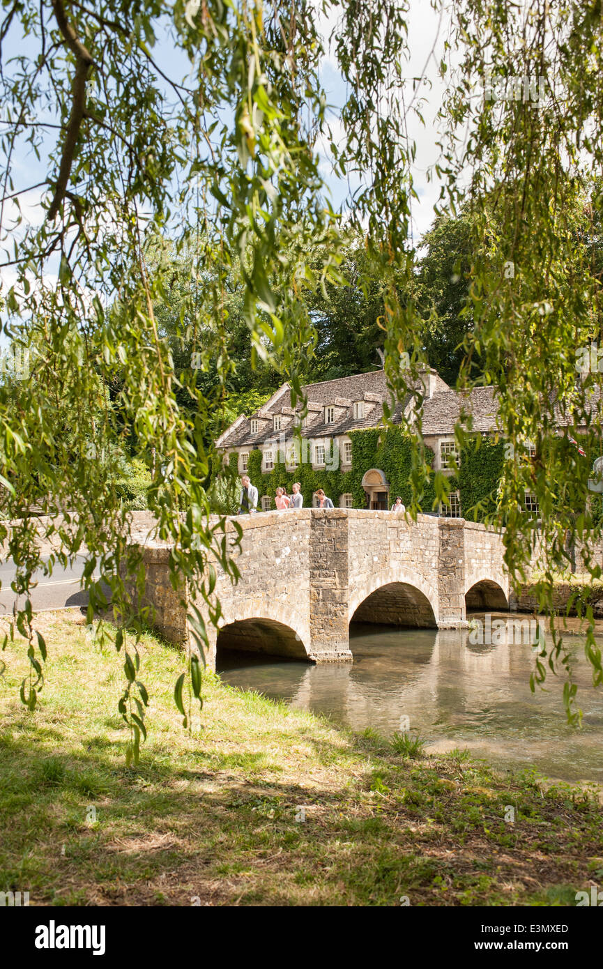 Il ponte sul Fiume Coln & The Swan Hotel nel grazioso villaggio Costwold di Bibury, Gloucestershire, Regno Unito su una giornata d'estate Foto Stock