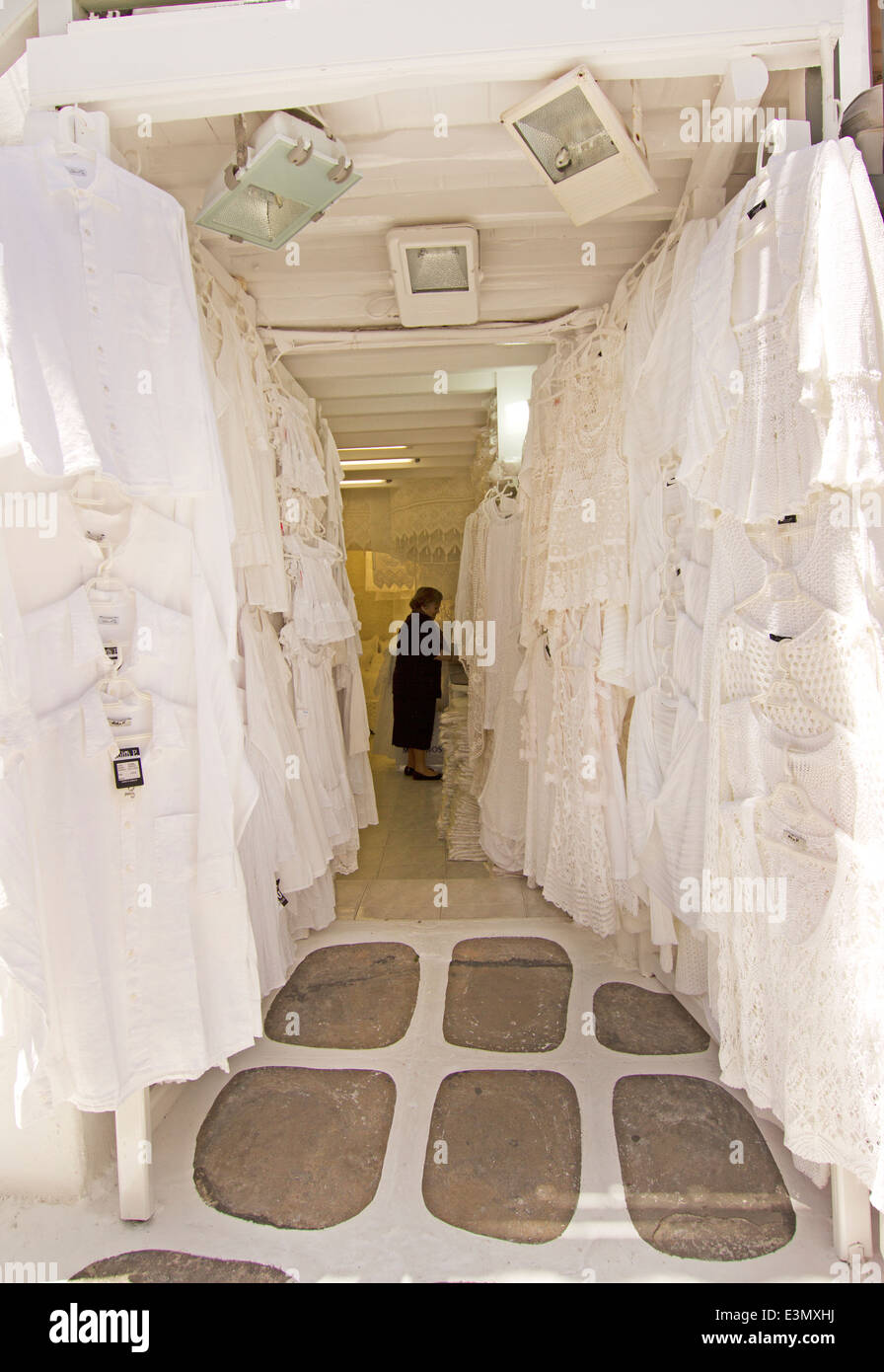 Bianco locale negozio di vestiti con abiti neri addetta a Mykonos, Grecia. Foto Stock