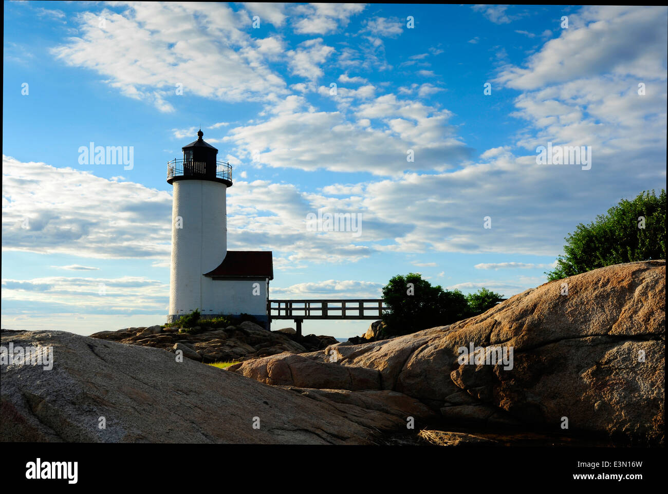 Sole che tramonta dietro alle rocce che circonda Annisquam lighthouse in Gloucester, Massachusetts. Foto Stock