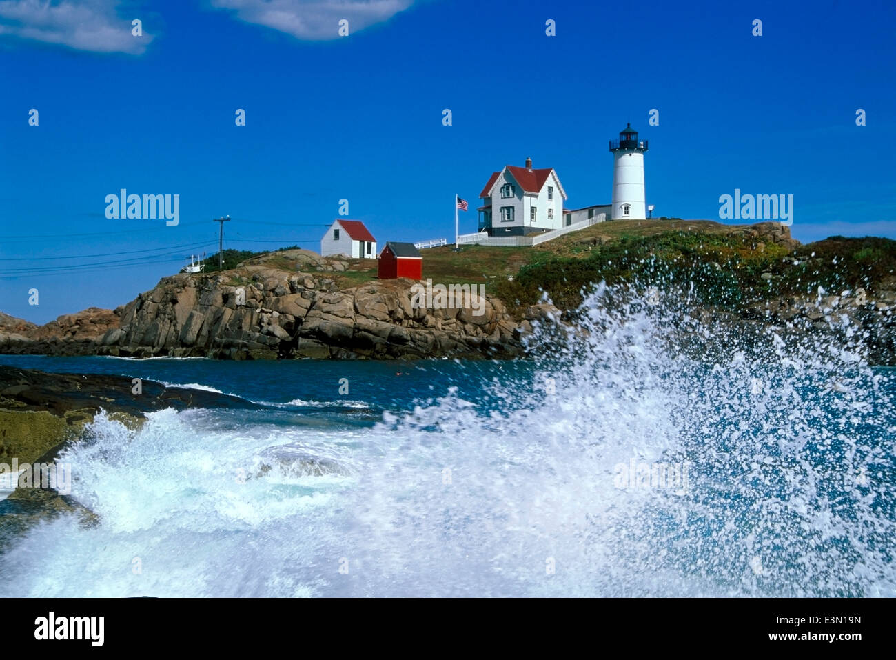 Nubble (Cape Neddick) luce fornisce viste mozzafiato delle onde che si infrangono sulla spiaggia rocciosa nelle vicinanze. Foto Stock