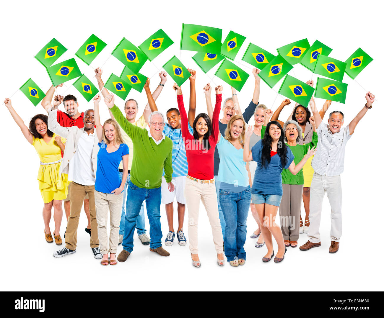 Allegro Multi-Ethnic gruppo di persone in piedi con le braccia alzate tenendo bandiera brasiliana. Foto Stock