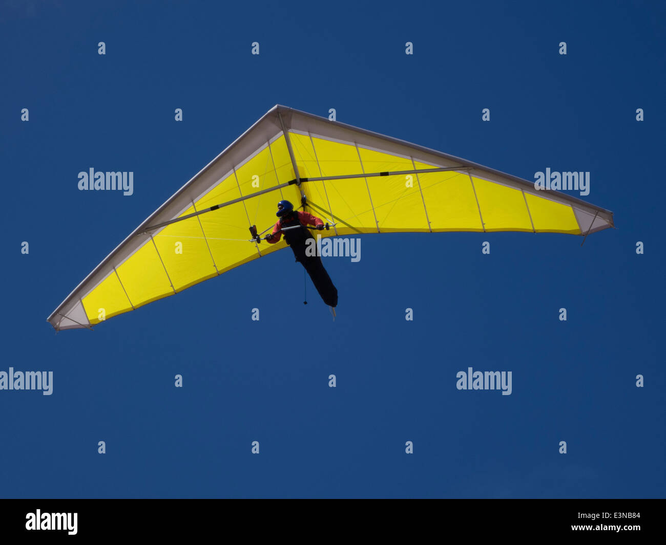 Basso angolo vista di una persona in deltaplano contro il cielo blu chiaro Foto Stock