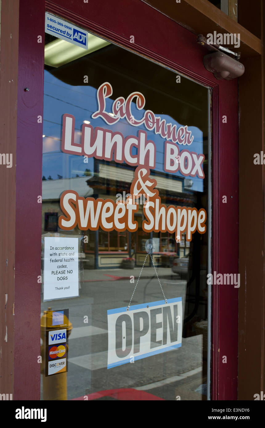 Porta in vetro segno del La Conner scatola di pranzo & Sweet Shop mostra una riflessione di negozi sulla strada principale (1° strada). Foto Stock