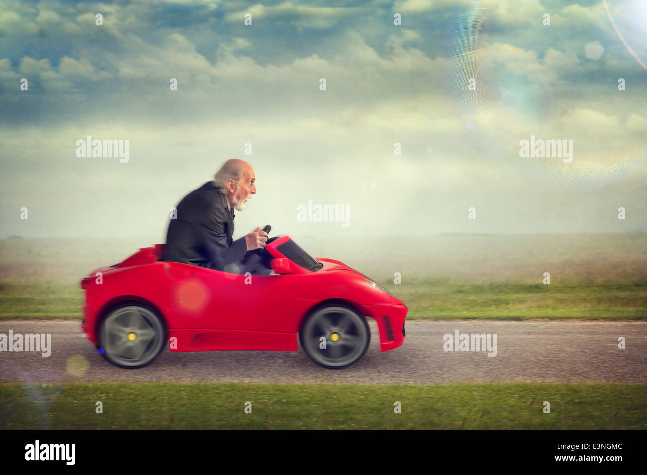 Senior uomo godendo il pilotaggio di un giocattolo auto racing Foto Stock