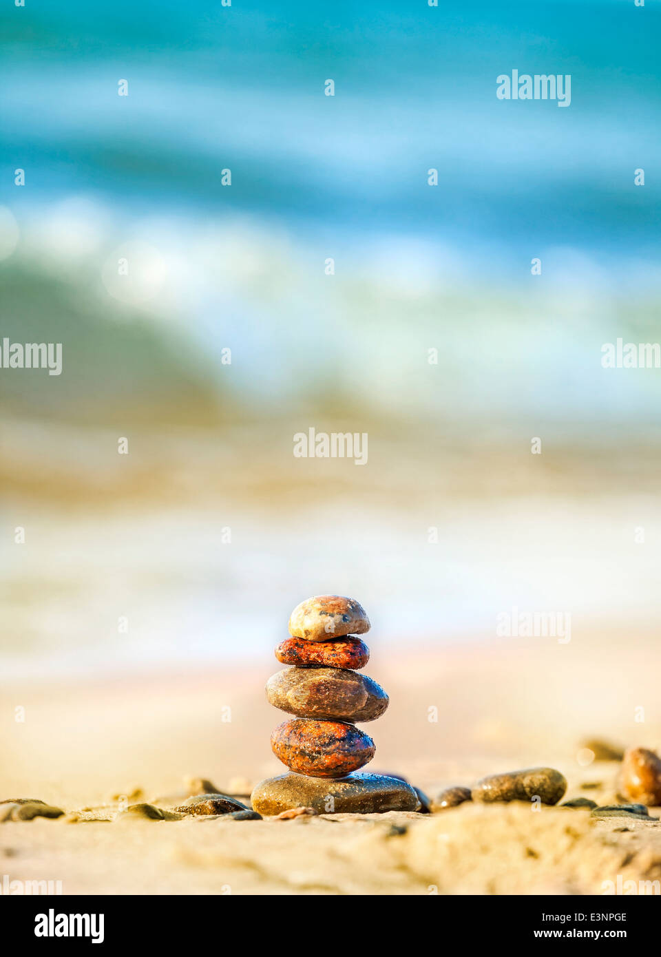 Piramide di pietre sulla sabbia che simboleggiano la pace e l armonia, blu oceano sullo sfondo . Foto Stock