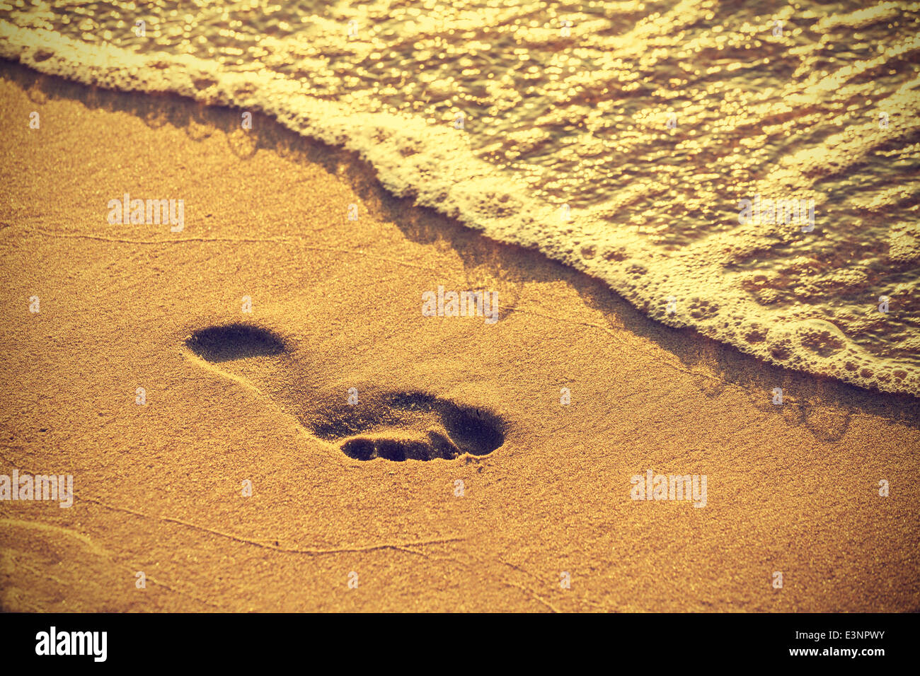 Impronta sulla spiaggia di sabbia lungo il bordo di mare, vintage stile retrò. Foto Stock