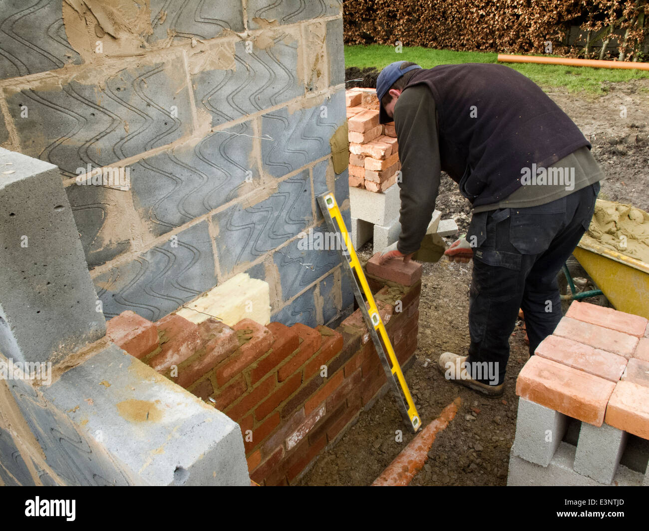 Auto costruzione di casa, muratore in corso di posa dei mattoni esterno Foto Stock
