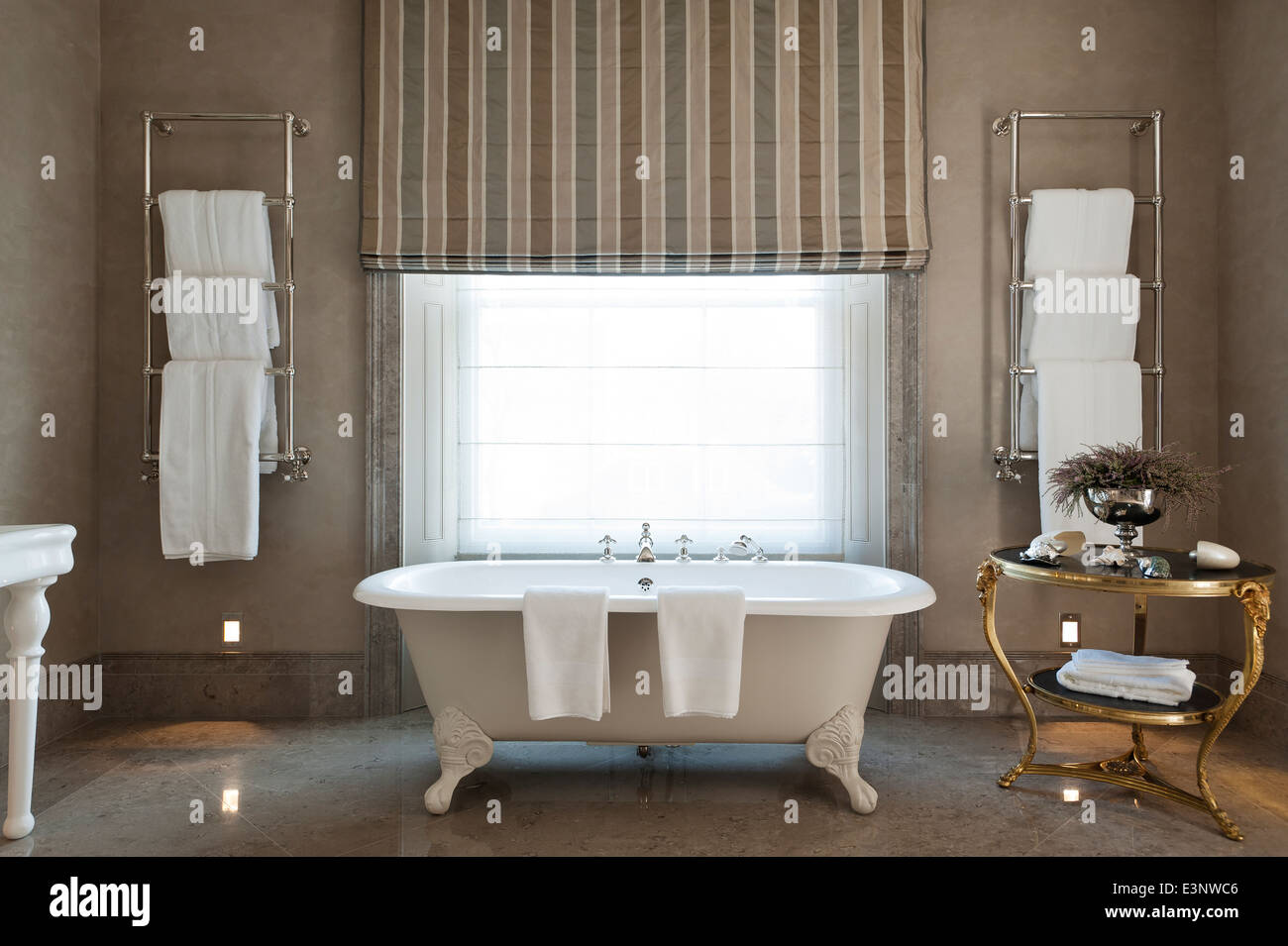 Free standing piede artiglio Le Piaf bagno da Catchpole & Rye in bagno con pavimenti in marmo grigio e appeso alla parete scaldasalviette Foto Stock