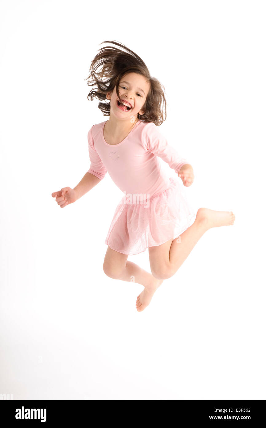 Ragazza in abito rosa saltando su sfondo bianco. (MR) Foto Stock