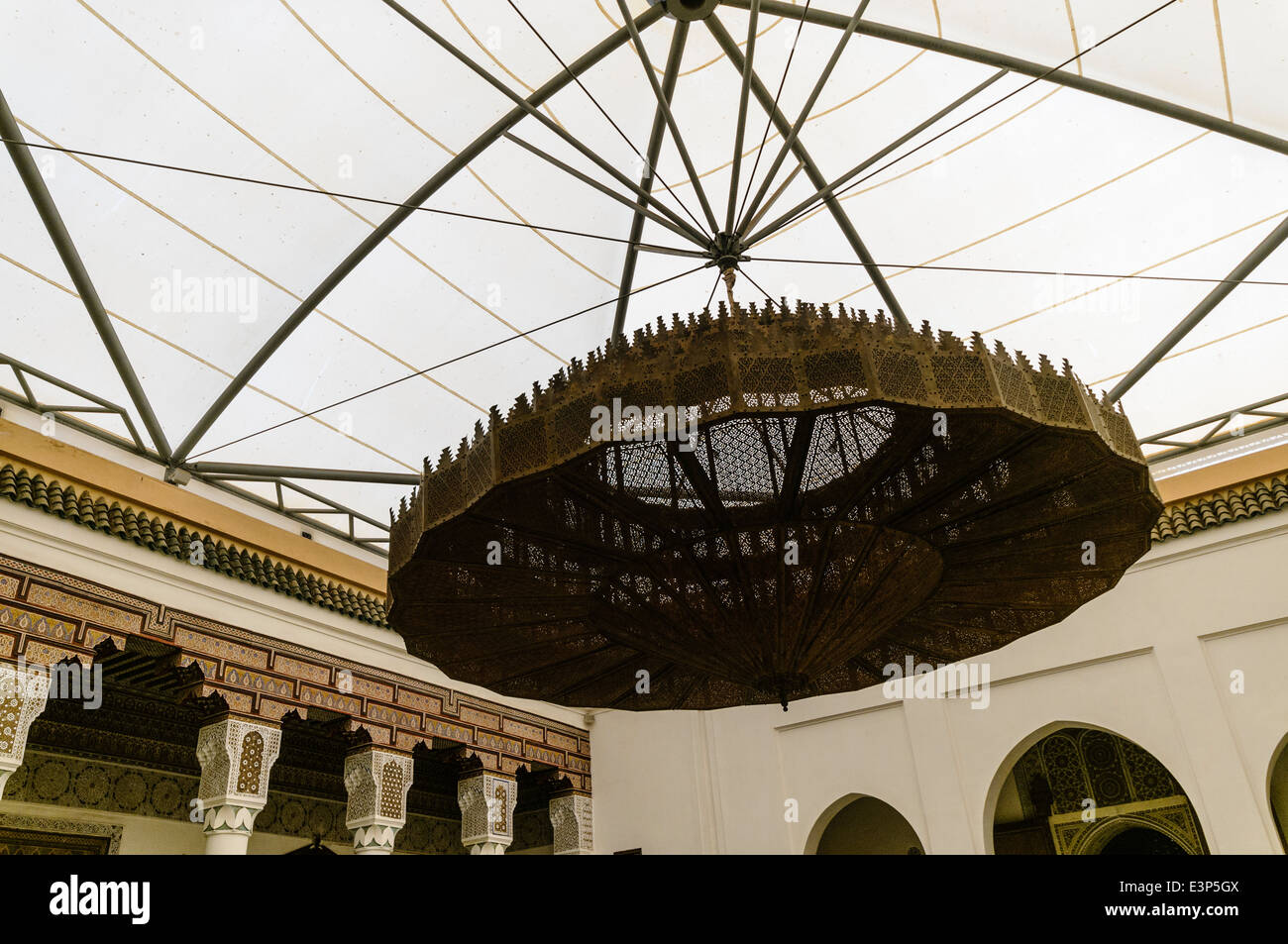 Una vecchia lampada in metallo con intricati traforature pende da una tented tessuto di copertura del tetto al di sopra del Museo di Marrakech, Marocco Foto Stock