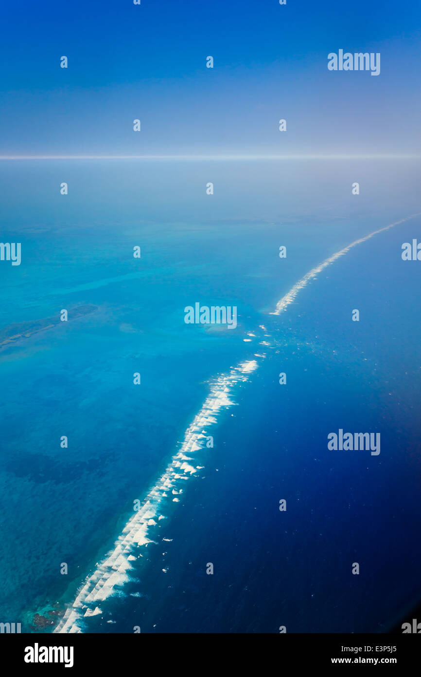 Vista aerea dell'oceano di onde che si infrangono sulla barriera corallina del Mar dei Caraibi al largo delle coste orientali dalla Belize Foto Stock