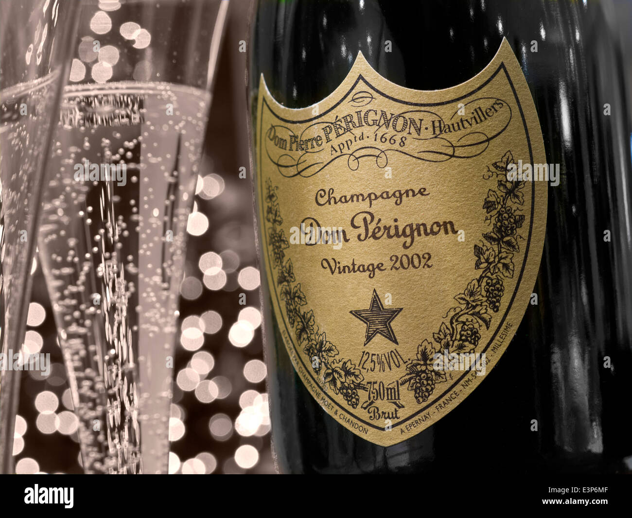 DOM Perignon bottiglia di champagne e appena spillata bicchieri di 2002 Dom Perignon vintage di lusso con una bottiglia di champagne e luci in background parziale retrò B&W Foto Stock