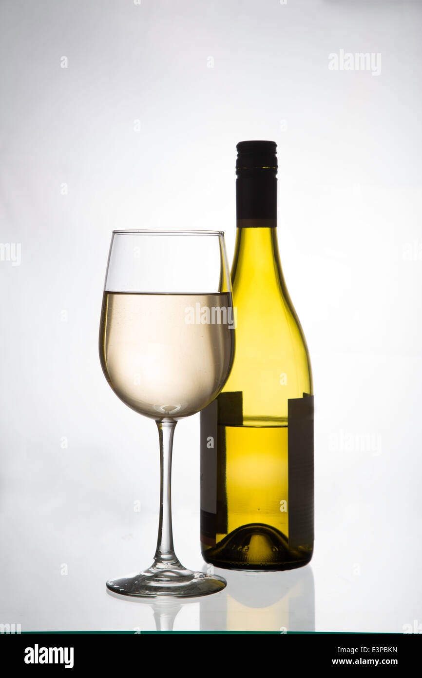 Un bicchiere di vino bianco e una bottiglia di vino bianco Foto Stock